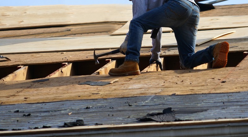 A commercial roof being removed by a handyman by NorCal Roofing & Gutters