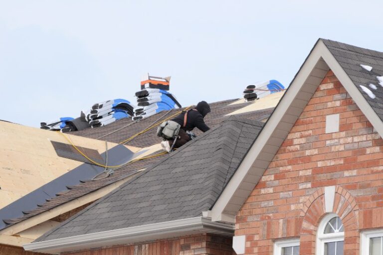 Someone on a roof replacing the shingles by NorCal Roofing & Gutters