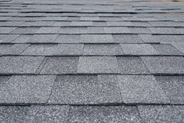 A close-up of grey shingles on a house by NorCal Roofing & Gutters