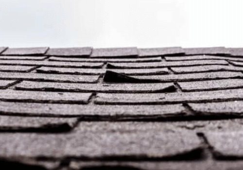 A close-up of roofing shingles that are separating from a roof by NorCal Roofing & Gutters