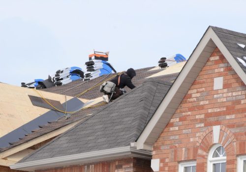 Someone on a roof replacing the shingles by NorCal Roofing & Gutters